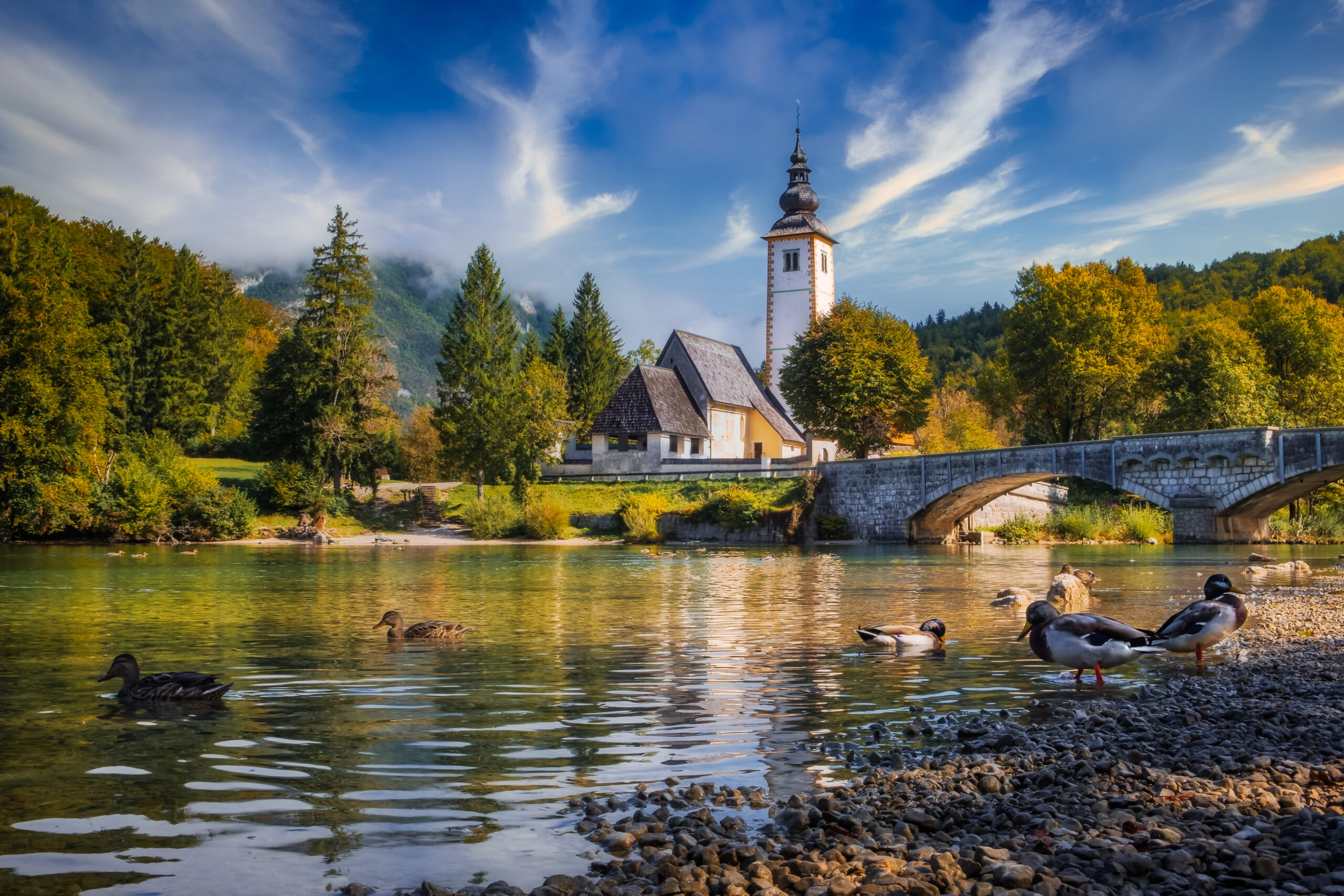 Scenic view of Lake Bohinj church with beautiful colorful foliag
